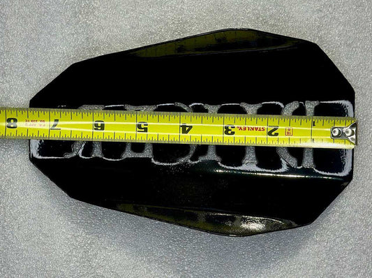 swappable handguard shells gloss black outlaw with measuring tape for size reference on a gray background.