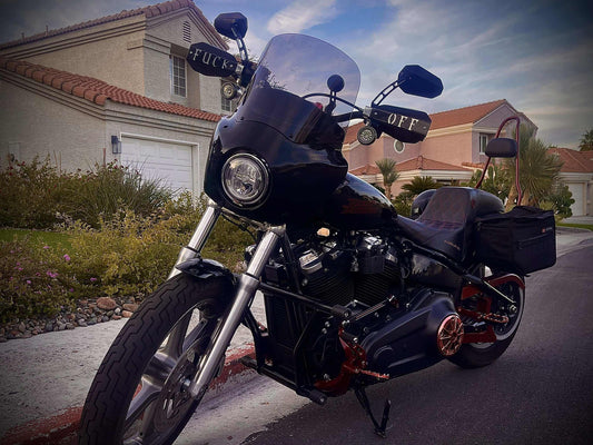 Motorcycle hand guards benefits on a custom motorcycle parked on a residential street.